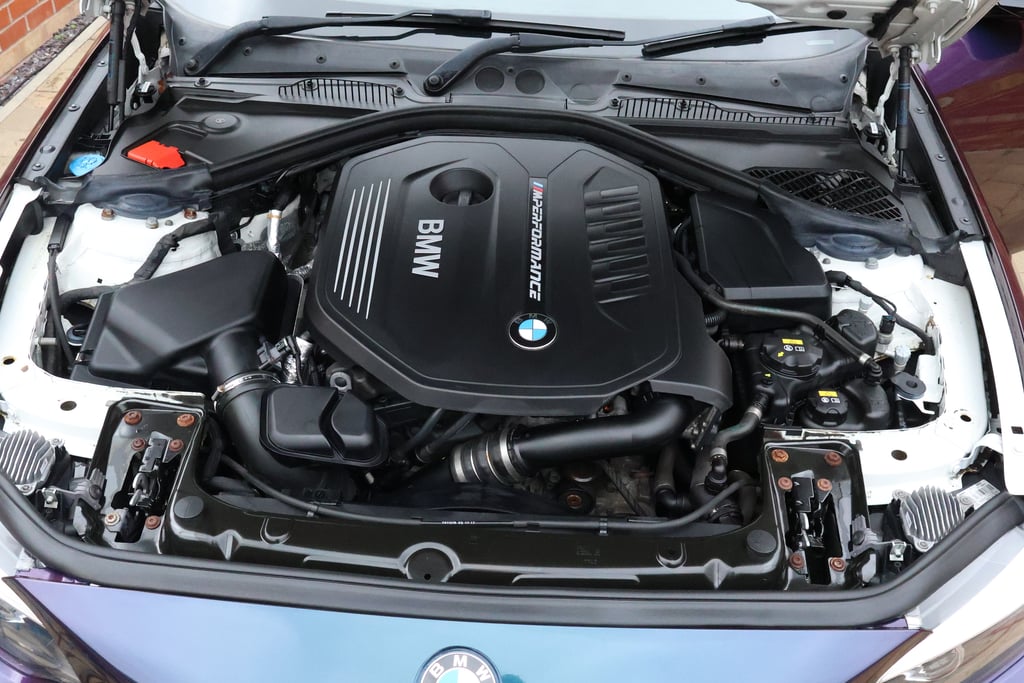The same BMW B58 engine bay after cleaning, covers satin black and the bay clear of dust