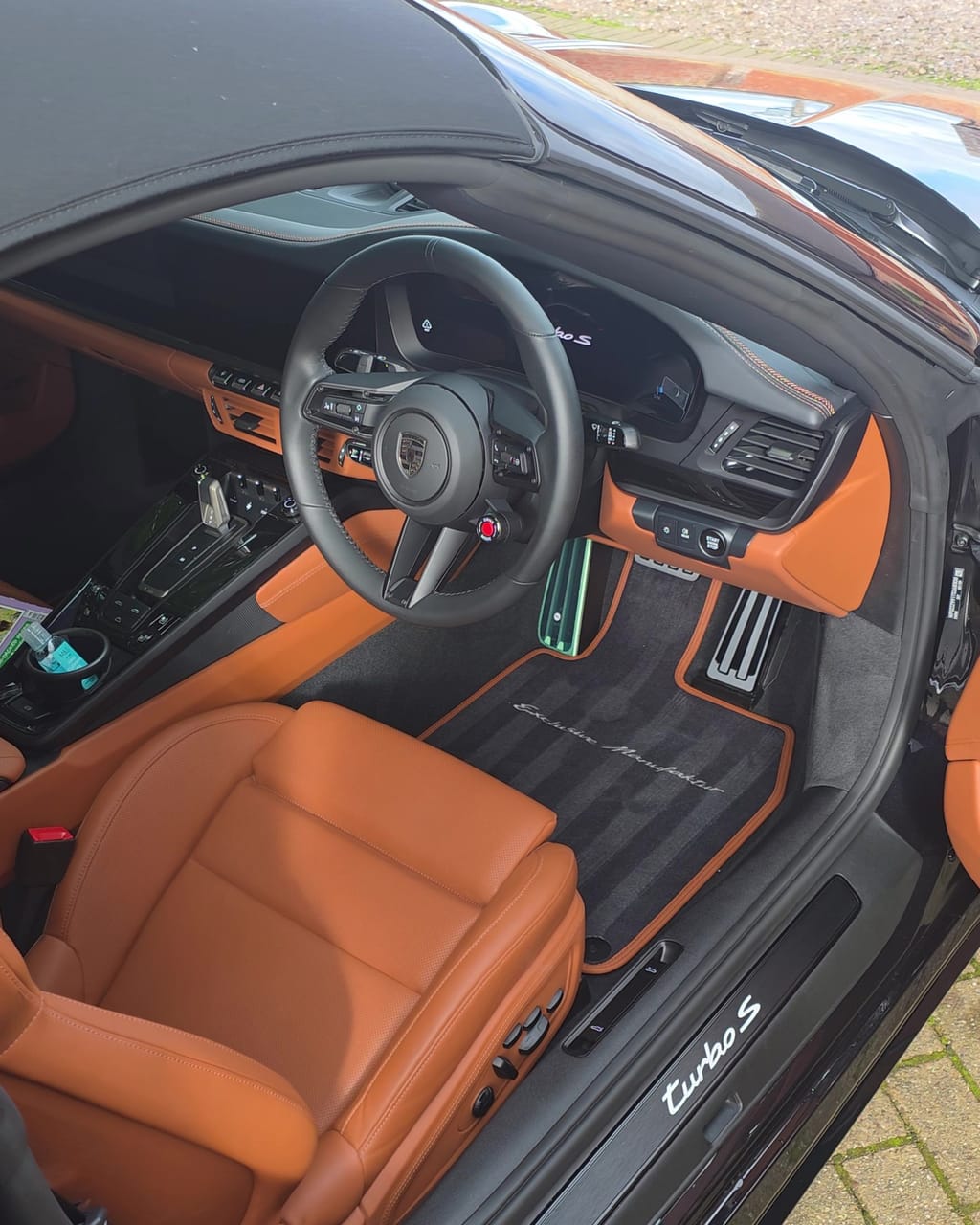 The same Porsche cognac leather interior after the valet, seats and mats clean and the sill plate wiped