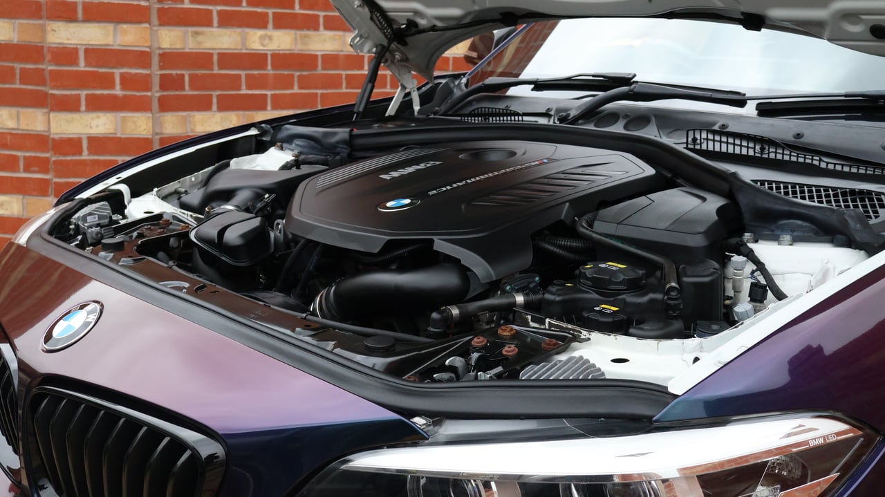 BMW M140i engine bay cleaned and dressed, bonnet raised on the driveway