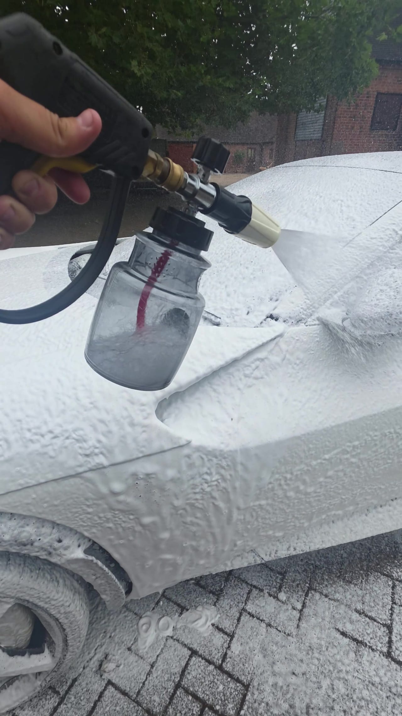 Thick snow foam dwelling on paintwork, lifting loose dirt before any contact washing