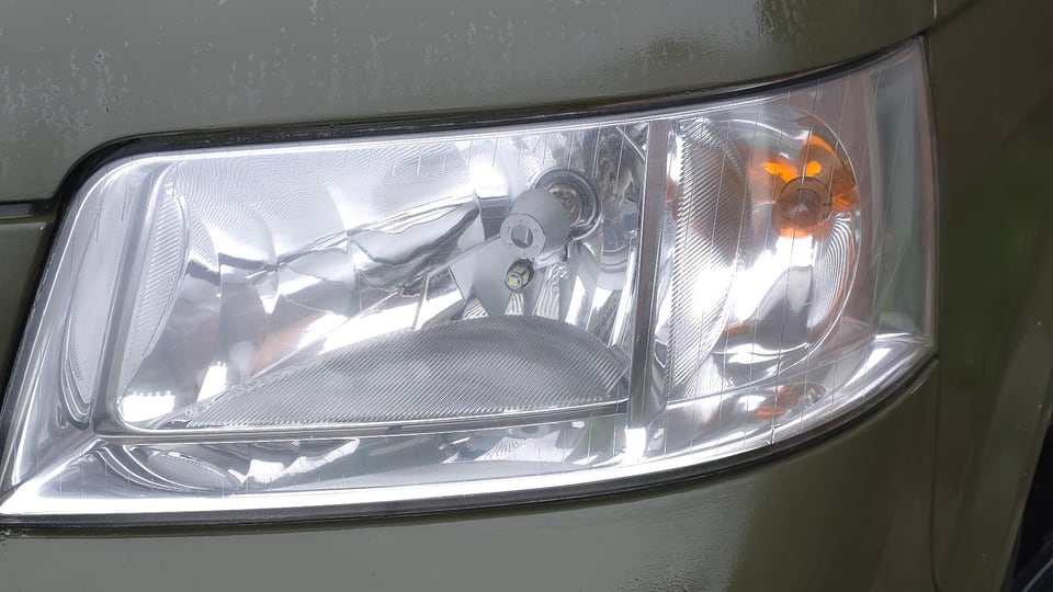 A VW Transporter T5 headlight in Wolverhampton after restoration, the lens clear enough to see the reflector and bulb behind it