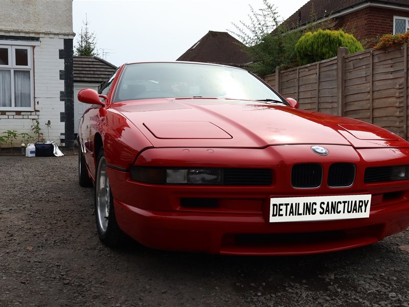 Red BMW 8 Series side profile with mirror gloss paintwork