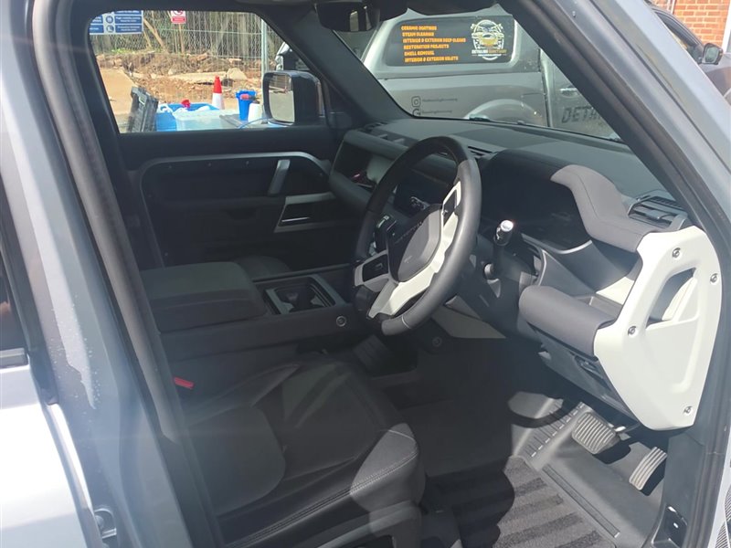 Land Rover Defender cabin with white-trimmed steering wheel after an interior deep clean