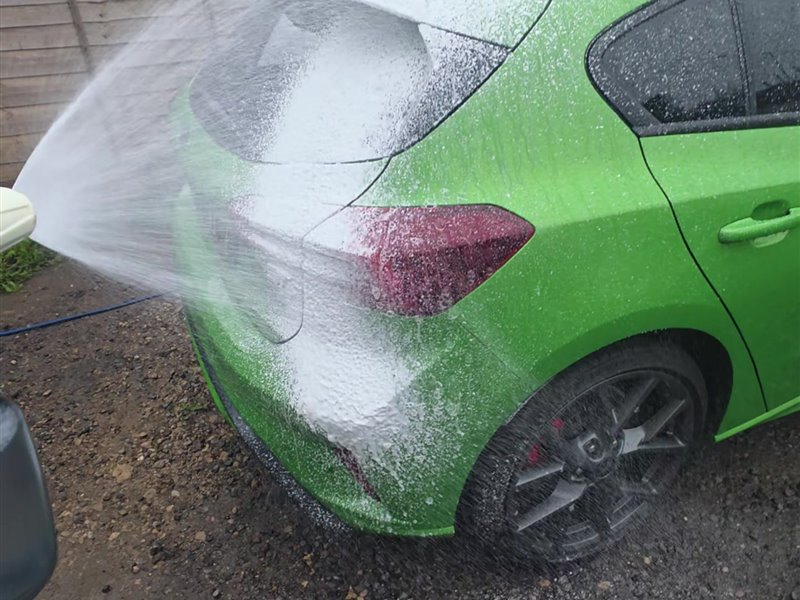 Green Ford Focus ST being snow foamed on a driveway