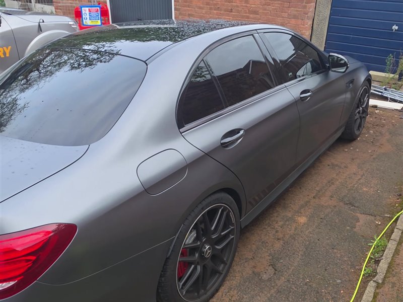 Satin grey Mercedes-AMG E63 rear three-quarter view after a maintenance valet