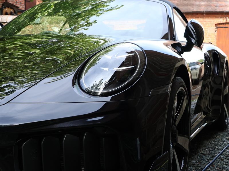 Black Porsche paintwork after decontamination, reflecting cleanly